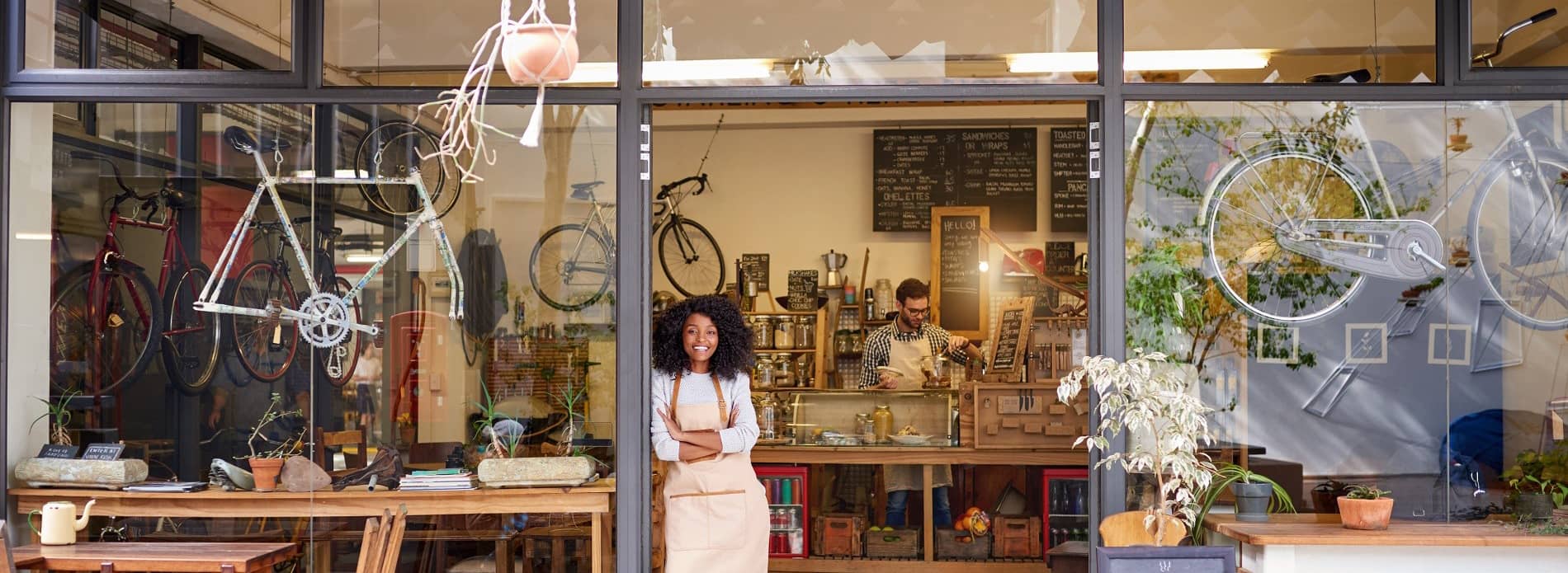 woman standing in the doorway of her bike shop small business
