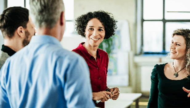 woman speaking to group of colleagues