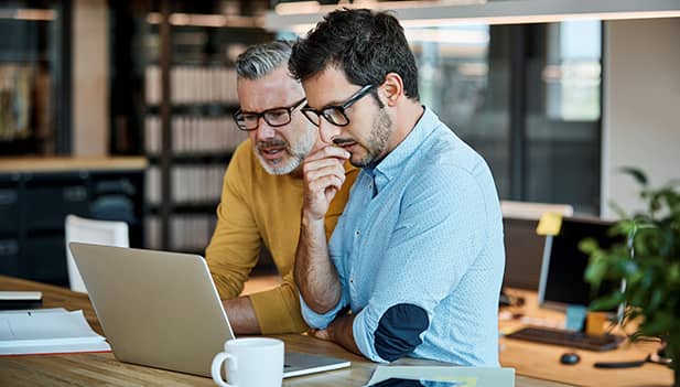 2 men looking at a laptop