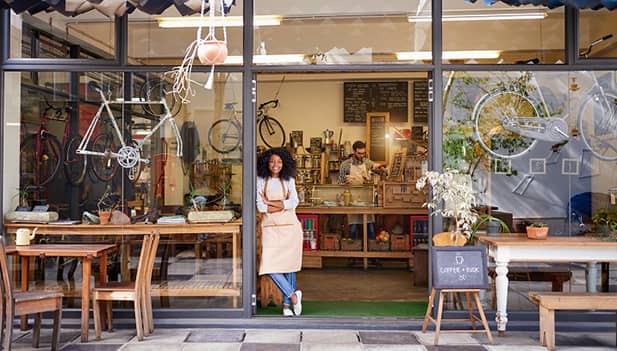 lady standing proud in shop doorway of own cycle business