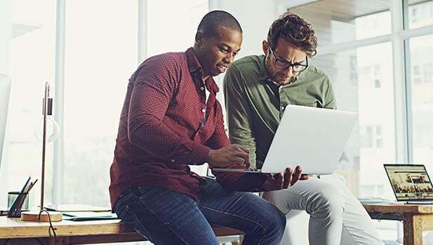 Two men looking at a laptop