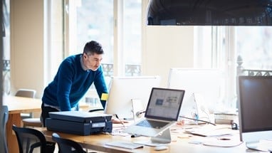 Man standing over laptop