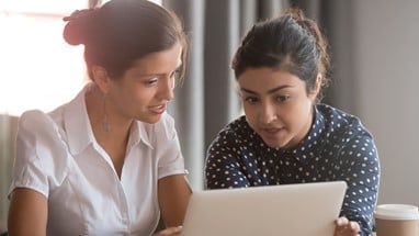 Two women looking at laptop