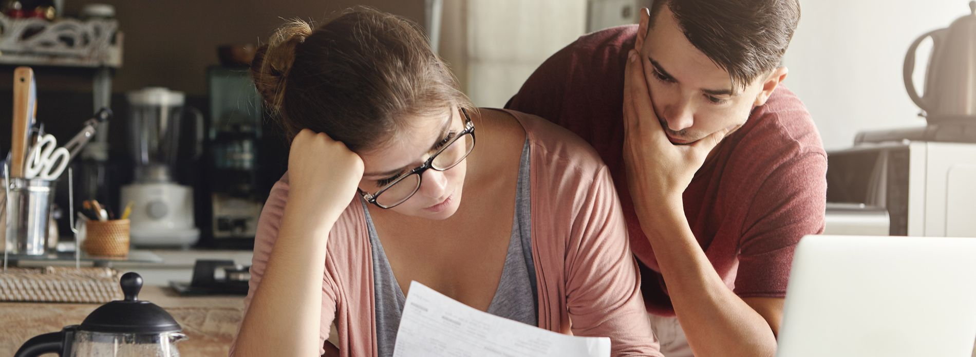 couple-looking-worried-at-bill-1900x695