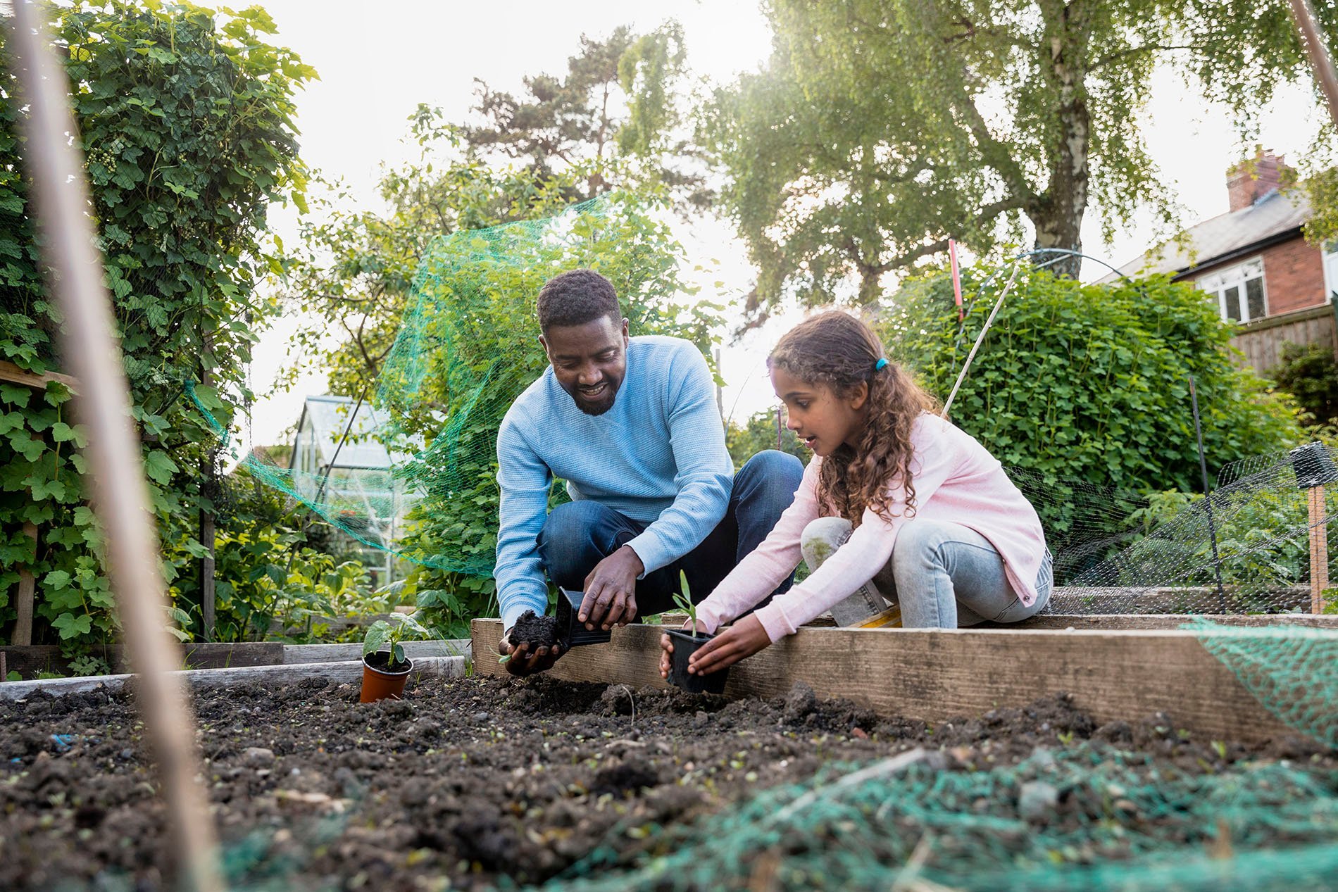 girl and dad gardening